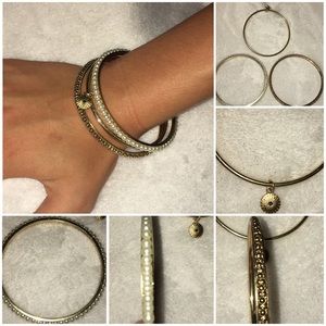 3 gold, metal bracelets with different patterns.